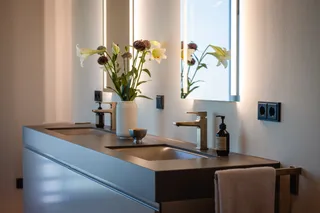 Doppelwaschtisch mit beleuchteten Spiegeln und Armaturen in Messing-Optik