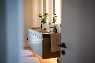 Blick ins Bad mit schwebendem Doppelwaschtisch und beleuchteten Spiegeln